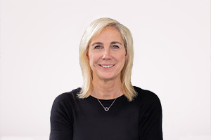 Porträtfoto von Susann Behling, Abteilungsleiterin für Strategie und Zukunftssicherung. Sie trägt einen schwarzen Pullover und eine silberne Halskette. Sie hat schulterlanges, blondes Haar und lächelt freundlich in die Kamera.